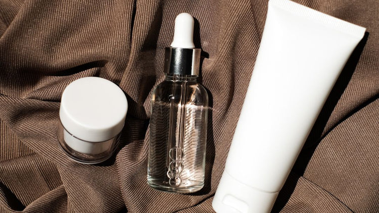 Cleanser, serum and moisturiser arranged in the correct skincare layering order for a daily skincare routine.