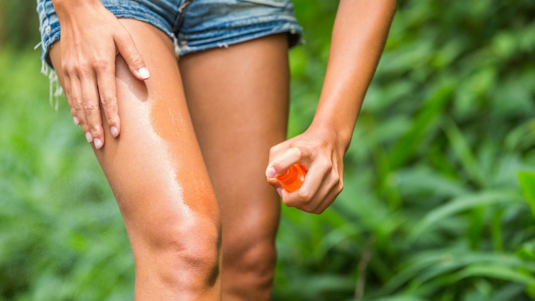 Person using insect repellent outdoors to prevent insect bites and midge bites in Ireland