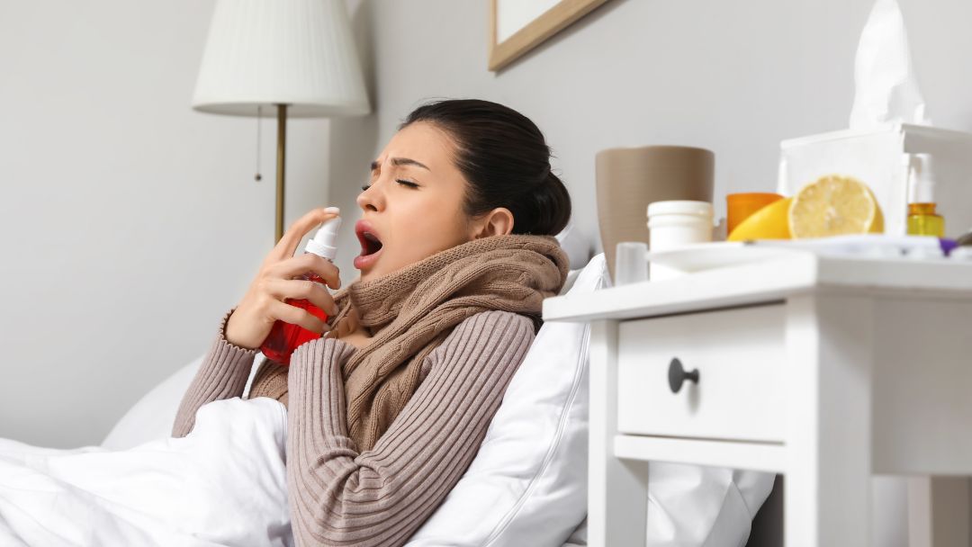 Person using a throat spray with sore throat lozenges for fast sore throat relief.