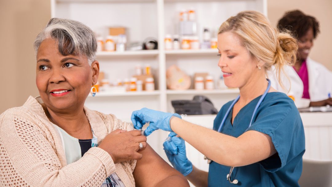 Woman receiving a flu vaccination from a healthcare professional at a pharmacy