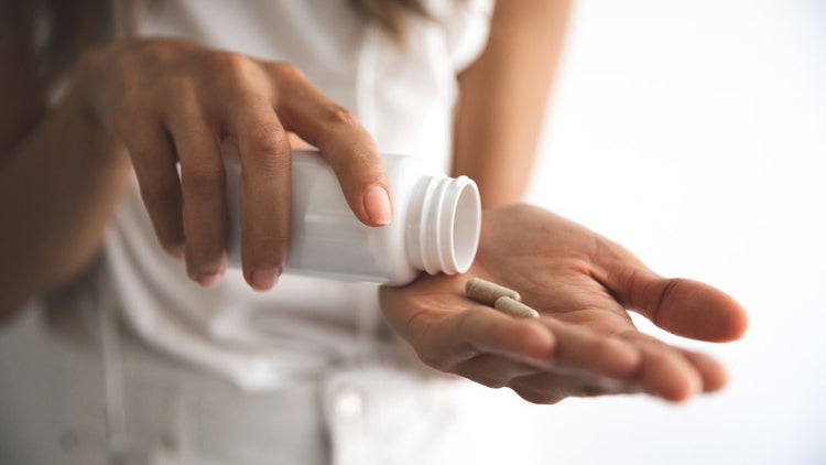 Woman taking supplements to support PMS and hormonal health
