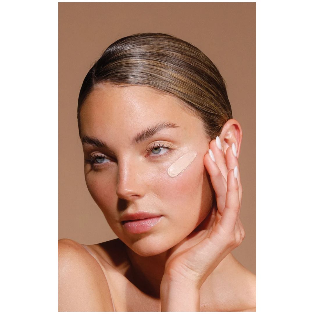 Airyday Mineral Mousse SPF50+ Dreamscreen on a womans cheek on a brown background
