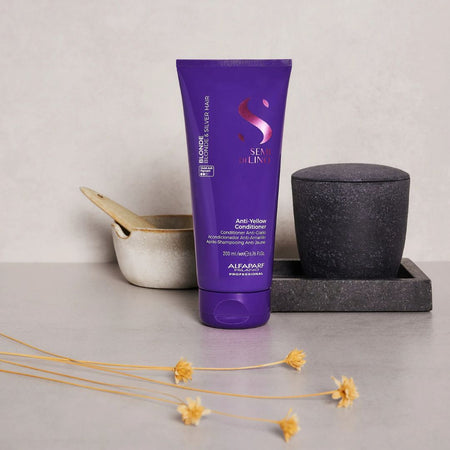 Purple conditioner bottle with decorative elements on a neutral background