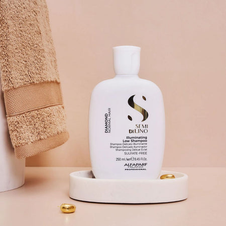 Shampoo bottle with towel and gold balls on a beige background