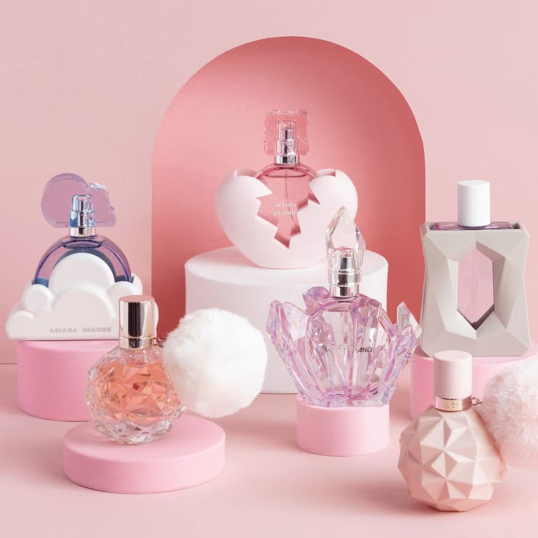 Collection of ariana grande perfume bottles on a pink background