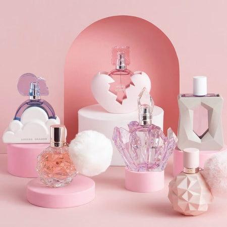 Collection of ariana grande perfume bottles on a pink background