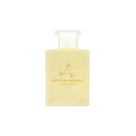 A rectangular frosted glass bottle of Aromatherapy Associates London body wash, filled with pale yellow liquid and featuring a gold logo and text on the front, set against a plain white background.