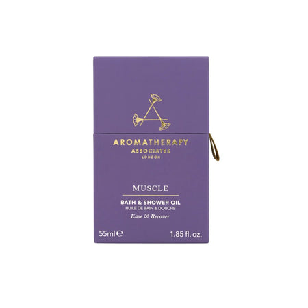 A purple rectangular box of Aromatherapy Associates London Muscle Bath & Shower Oil, featuring gold lettering and a small gold pull tab on the right side, set against a plain white background.