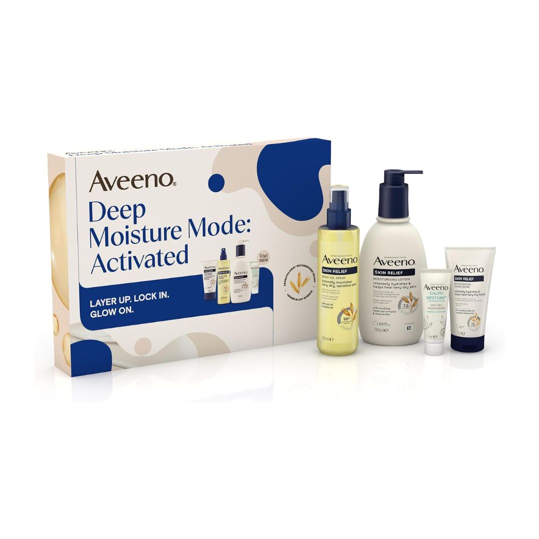 Aveeno Deep Moisture Mode: Activated skincare gift set featuring a white and blue box with four products: a yellow glow oil bottle, a white body lotion bottle, a small treatment spray bottle, and a white cream tube.