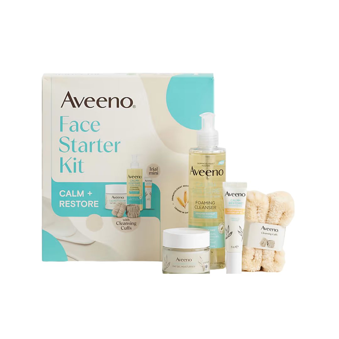Aveeno Face Starter Kit with Calm + Restore, featuring the product box, a foaming cleanser bottle, a cream treatment tube, a jar, and a set of beige washcloths on a white background.