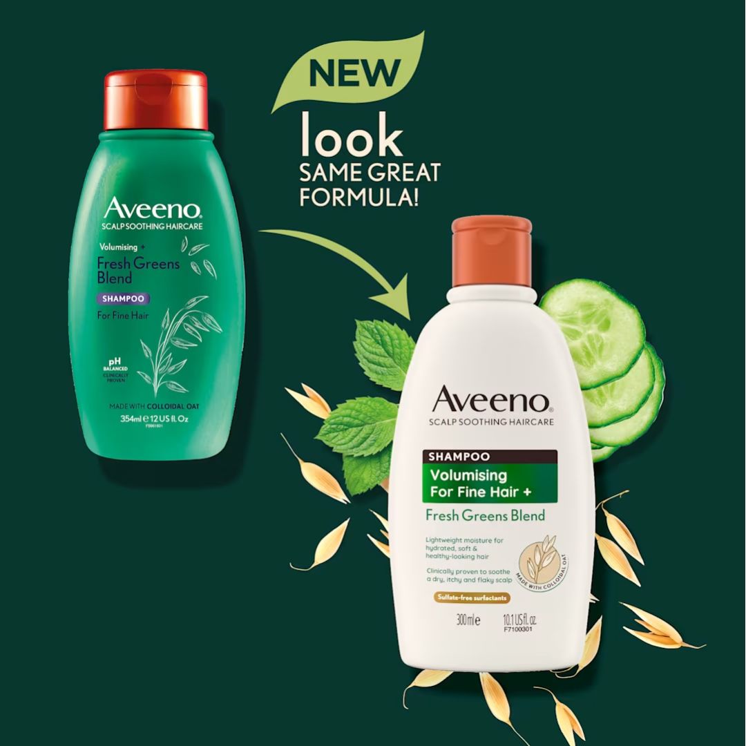 Aveeno Scalp and Haircare Fresh Greens Blend shampoo shown in two bottles: a green bottle with a copper cap on the left, and a white bottle with an orange cap on the right. The image includes promotional text reading 'NEW look SAME GREAT FORMULA!' with decorative leaves, oats, cucumber slices, and an arrow on a dark green background.