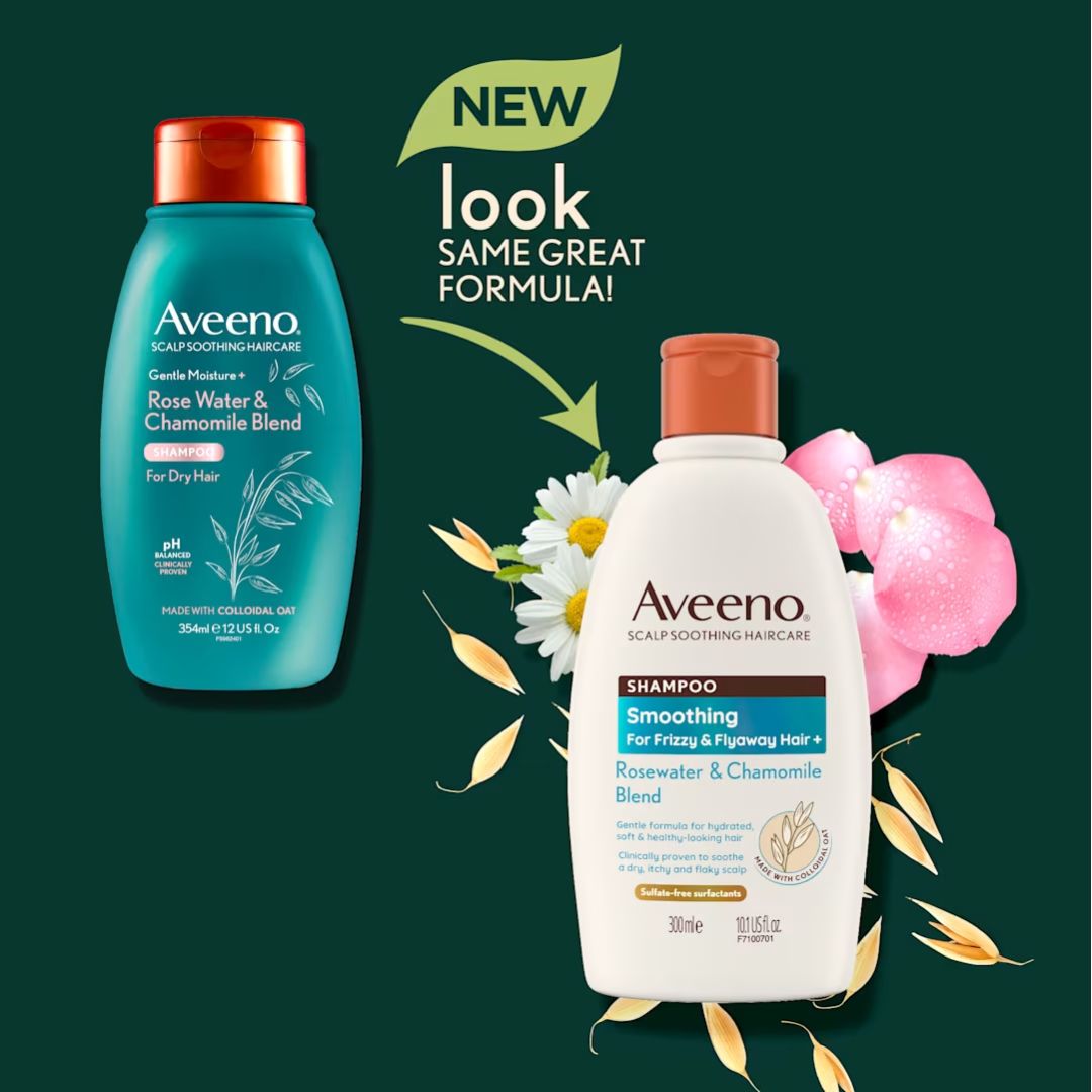 Two Aveeno Scalp and Soother Care haircare products on a dark green background: a teal bottle of Rose Water & Chamomile Blend shampoo on the left and a white bottle of Smoothing Shampoo on the right, with decorative flowers, leaves, and a green 'NEW look SAME GREAT FORMULA!' banner above.
