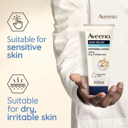 A person in a white lab coat holds a tube of Aveeno Skin Relief Soothing Lotion. The left side features informational text and icons stating it is suitable for sensitive skin and dry, irritable skin, set against a light beige background.