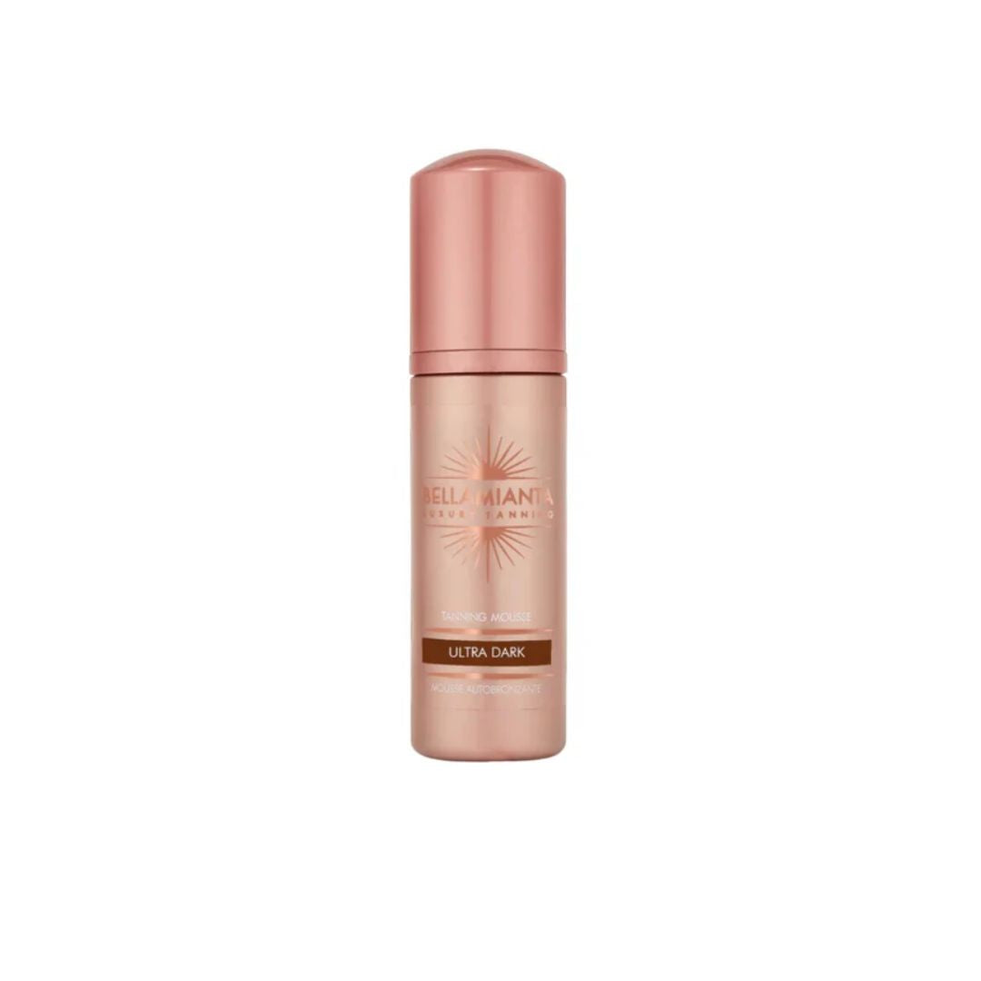 A single bottle of Bellamianta Ultra Dark tanning mousse in a metallic rose gold color, centered on a plain white background.