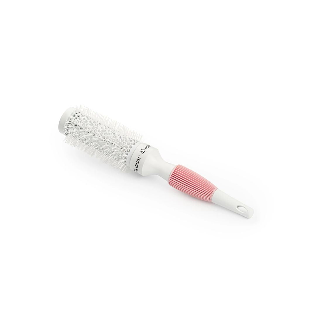 A round hairbrush with white bristles, a white plastic barrel, and a pink ribbed handle, shown on a plain white background.