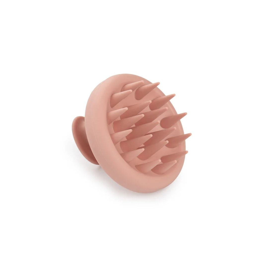 A dusty pink silicone scalp massage brush with soft silicone bristles, shown on a clean white background.