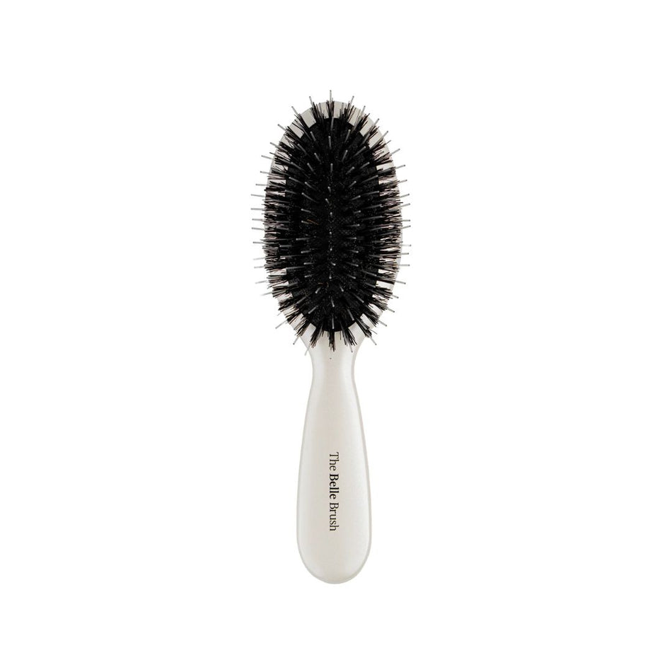A paddle-style hairbrush with black bristles and a glossy white handle, featuring the text 'The Red Velvet' printed vertically on the handle, set against a plain white background.