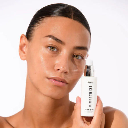 Woman holding a skincare product with a plain background BPerfect Skin Studio - Hydro Burst Eye Gel