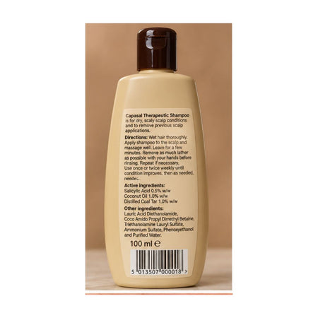 A 100 ml bottle of Capasal Therapeutic Shampoo shown from the back, featuring a beige body, dark brown cap, and printed product information on a brown background.