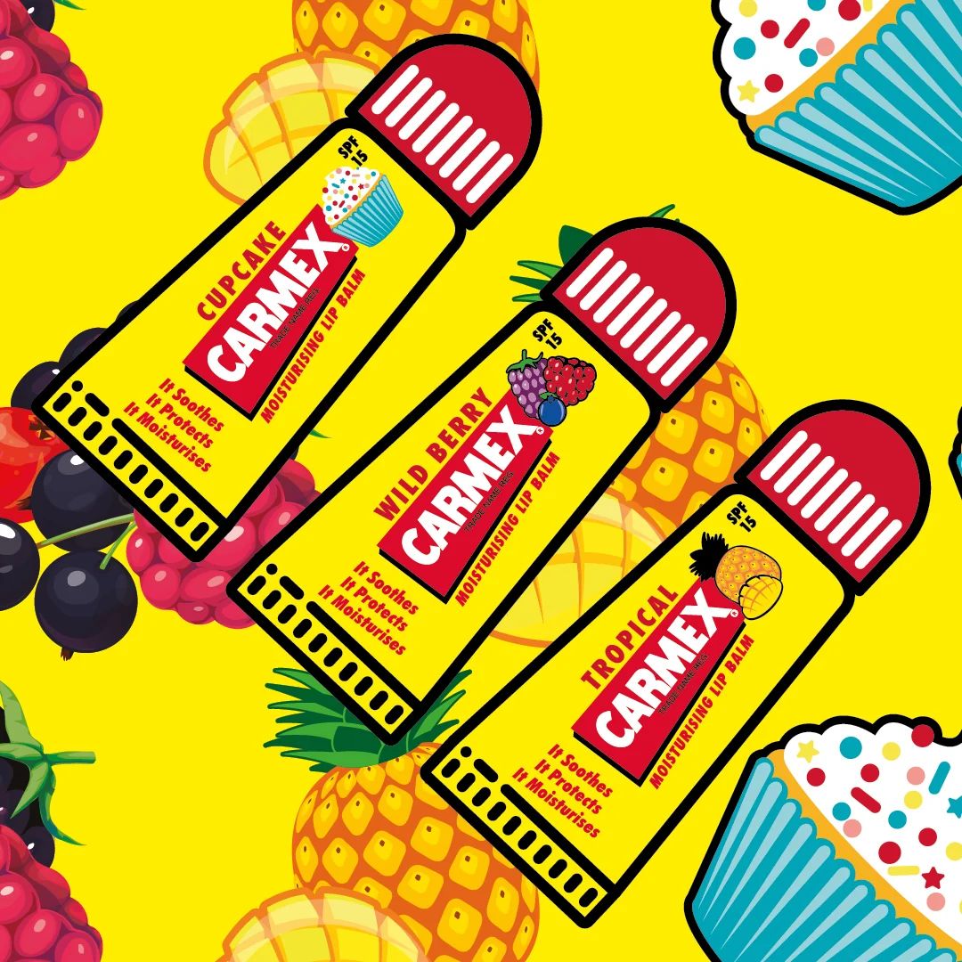 Carmex Minis SPF15 Lip Balm 3 Pack contents on a yellow fruity background