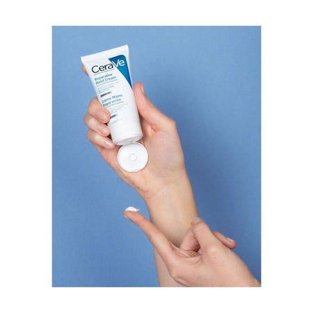 CeraVe Reparative Hand Cream in a white squeeze tube, shown from the back on a blue background.