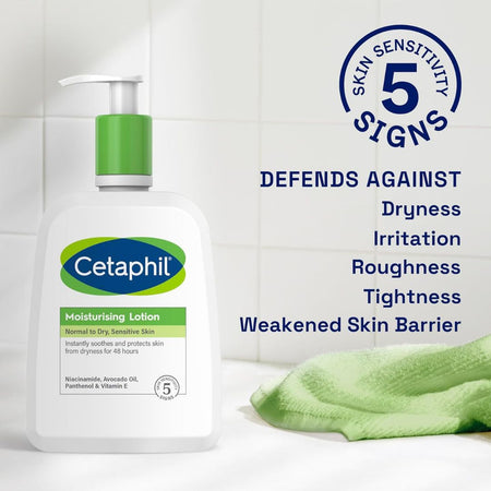 Cetaphil moisturizing lotion bottle with green towel on white tiled background
