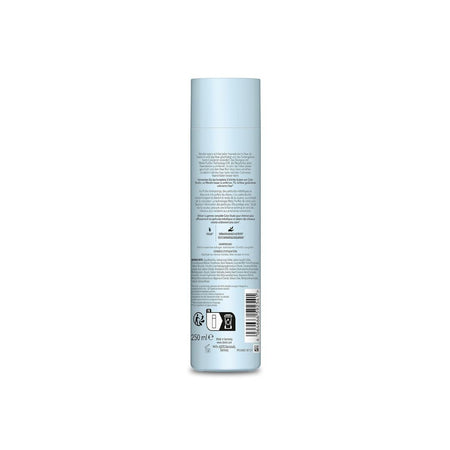 A light blue cylindrical bottle of hair product shown from the back, featuring detailed text, a barcode, and various certification logos on a plain white background.