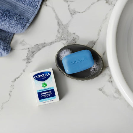Cuticura Mildly Medicated Bar Soap 100g on a marble bathroom counter