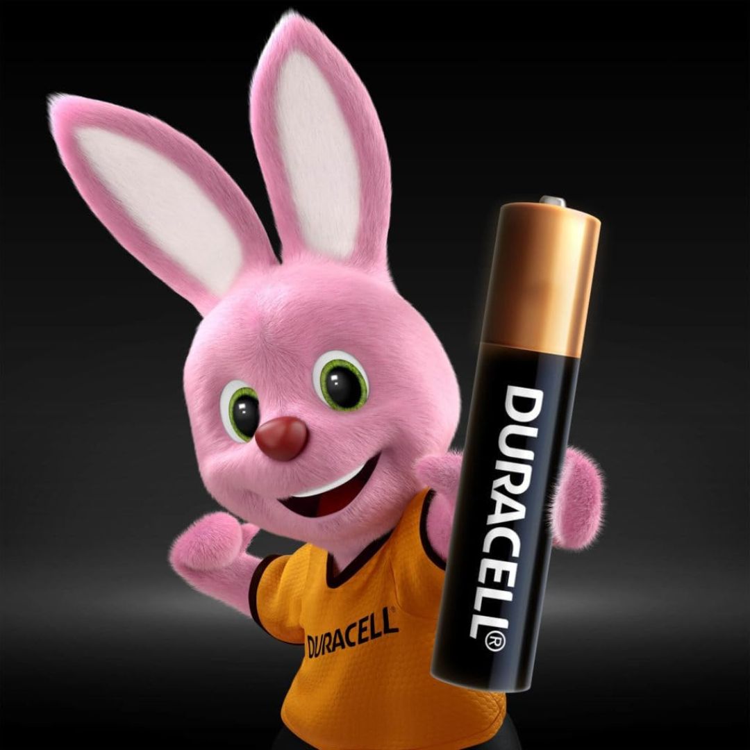 A pink cartoon rabbit mascot wearing a yellow Duracell shirt holds a black Duracell battery against a dark gradient background.