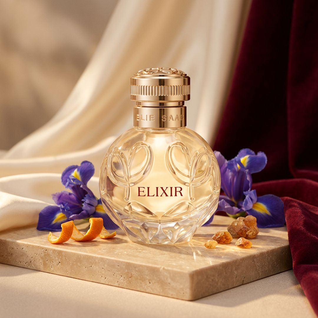 Elie Saab Elixir Eau de Parfum 50ml on a marble slate with flowers and orange peel