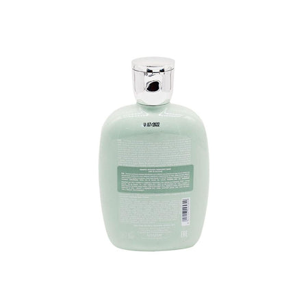 The back view of a light mint green bottle with a shiny silver cap, showing the product's barcode and text on a solid white background.