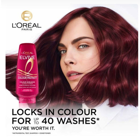 L'Oréal Paris Elvive Colour Protect shampoo bottle shown next to a model with long, wavy burgundy hair on a white background.
