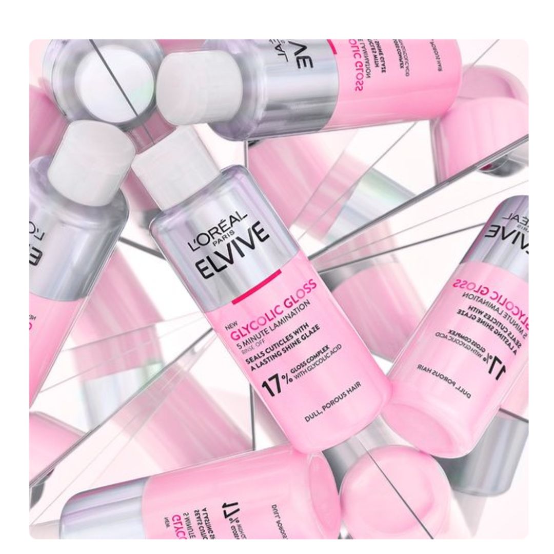 L'Orétal Paris Lévive Glycine Gloss hair serum bottles arranged in a mirrored, overlapping pattern. The bottles are pink and silver with white caps, showcasing the product packaging on a reflective surface.