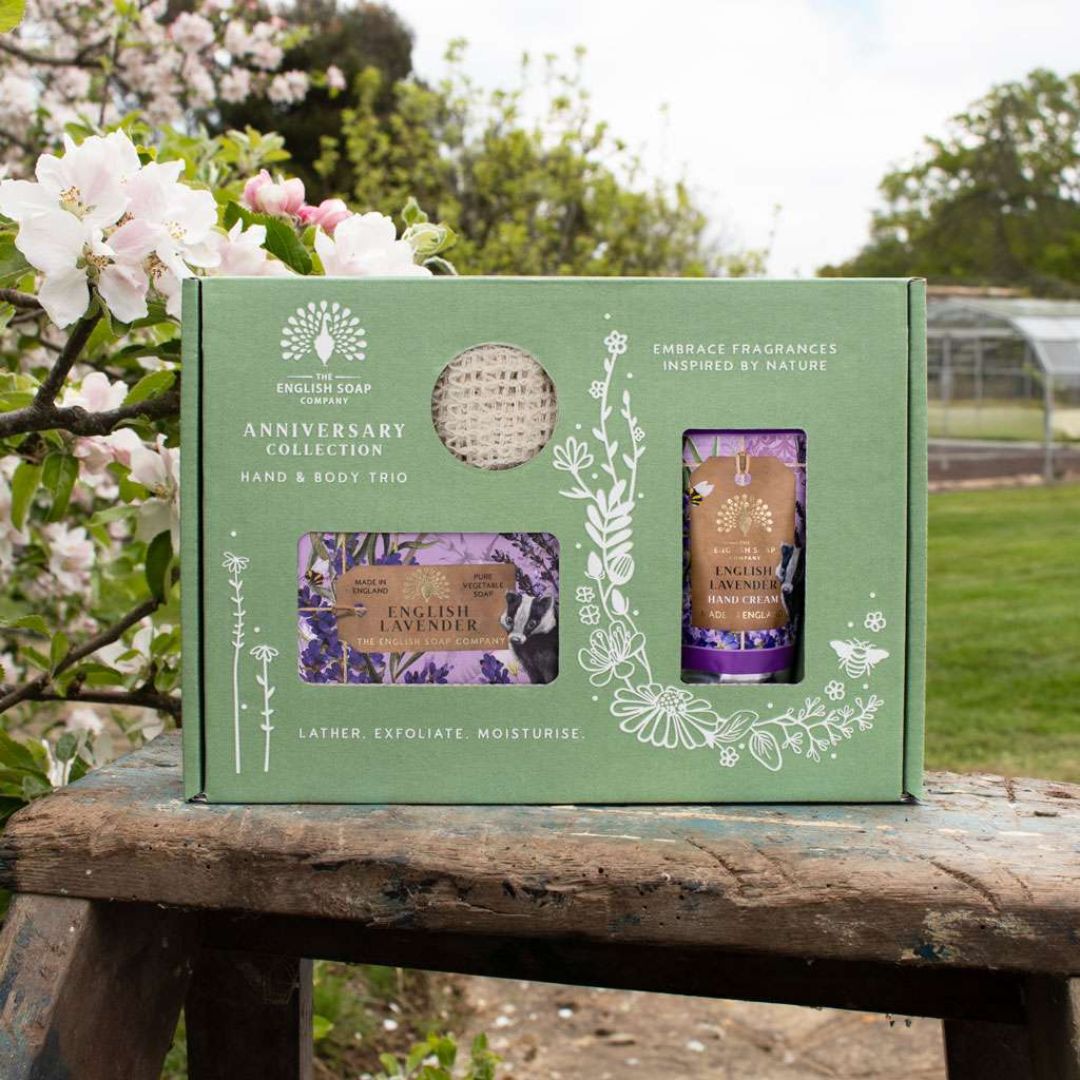The English Soap Company Lavender Hand & Body Trio on a floral garden background