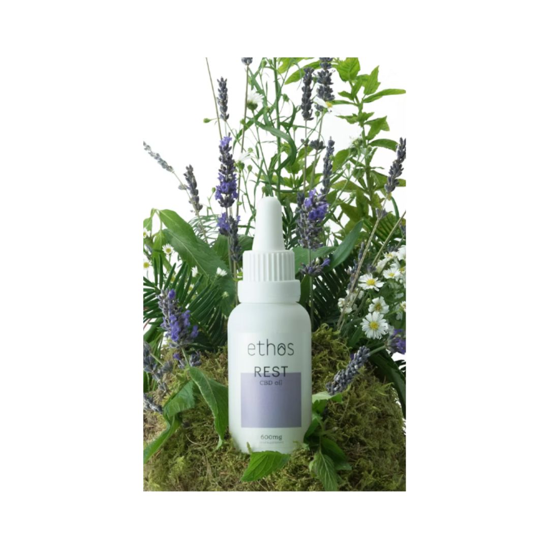 Ethos Rest CBD Oil 30ml surrounded by foliage