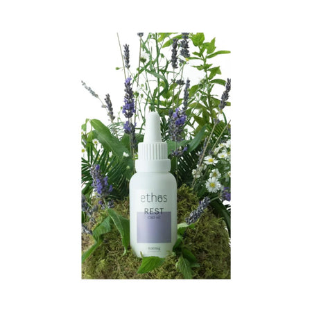 Ethos Rest CBD Oil 30ml surrounded by foliage