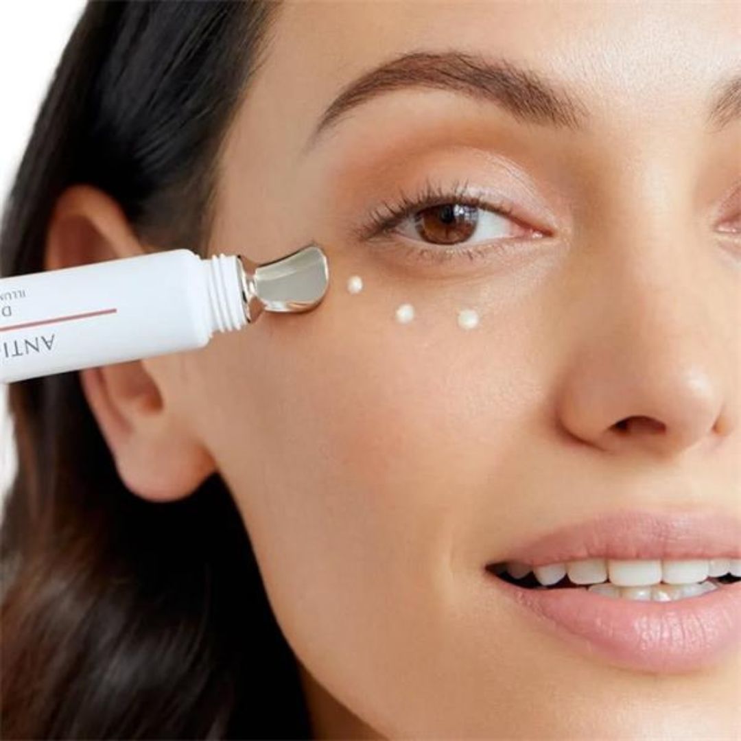 Woman applying a cosmetic product to her face with a applicator.