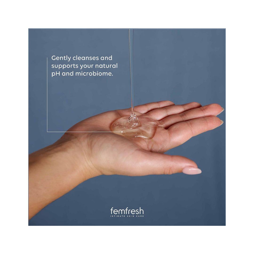 Femfresh 0% Sensitive Intimate Wash 250ml being pured into a person's hand on a blue background