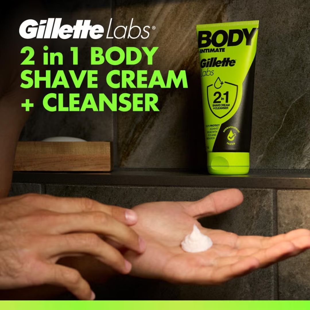 Gillette Labs 2 in 1 Body Shave Cream and Cleanser tube standing on a shelf next to a hand holding a dollop of white shaving cream, with promotional text on the left.