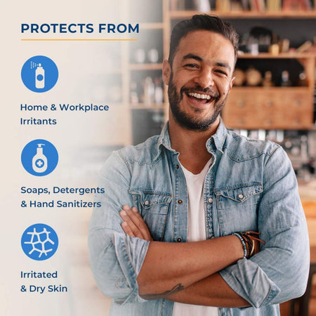 A smiling man in a light blue denim shirt stands with arms crossed in a home or office setting, with text on the left stating the product protects from home and workplace irritants, soaps, detergents, and hand sanitizers, and irritated and dry skin. Gloves in a bottle