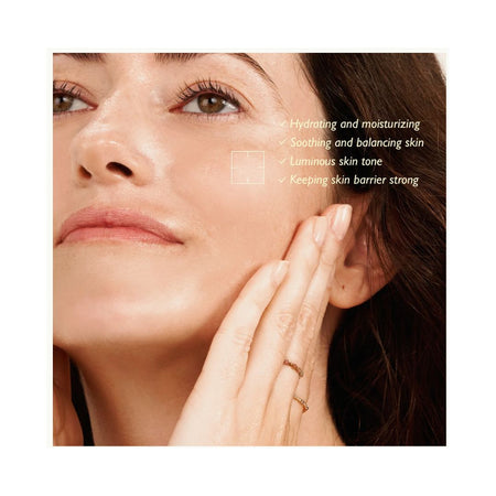 Close-up of a woman's face and hand touching her cheek, with text listing skincare benefits such as hydrating, moisturizing, soothing, and balancing skin.