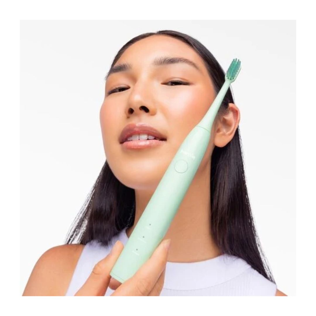 Hismile Electric Toothbrush – Green toothbrush being held up by a woman on a light green background