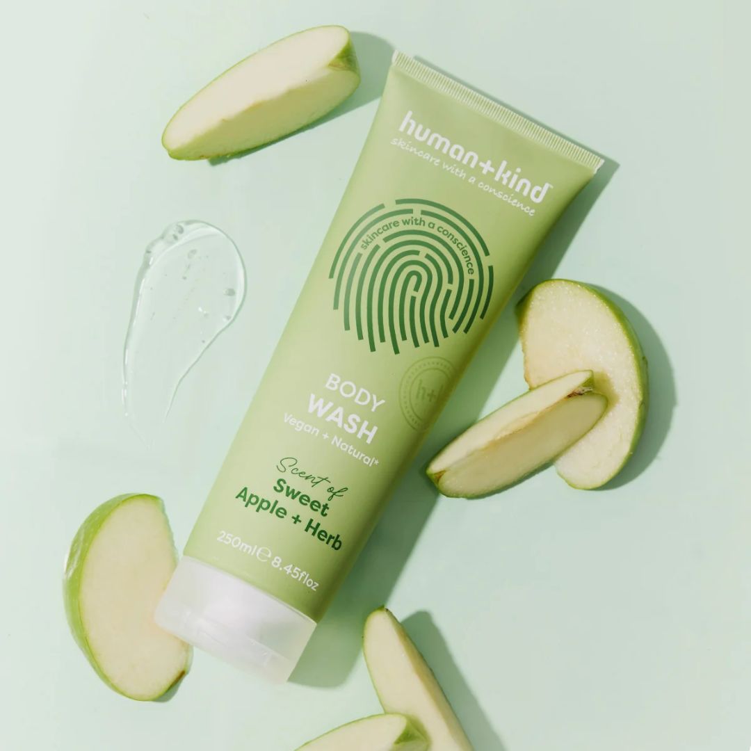 Human+Kind Sweet Apple + Herb Body Wash 250ml on a light green background  surounded by apple slices