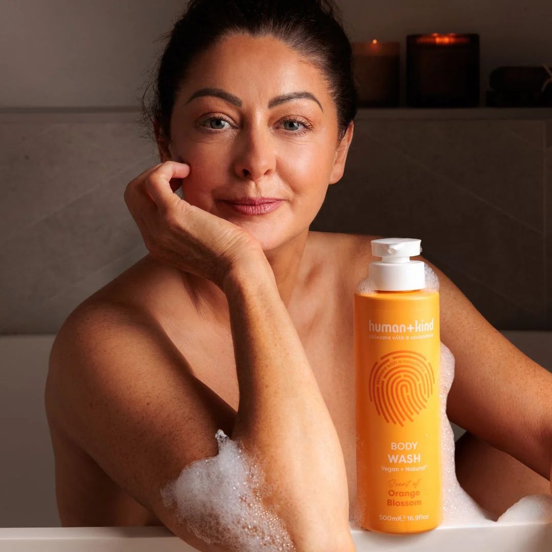 Human+Kind Orange Blossom Body Wash on a bath with a woman