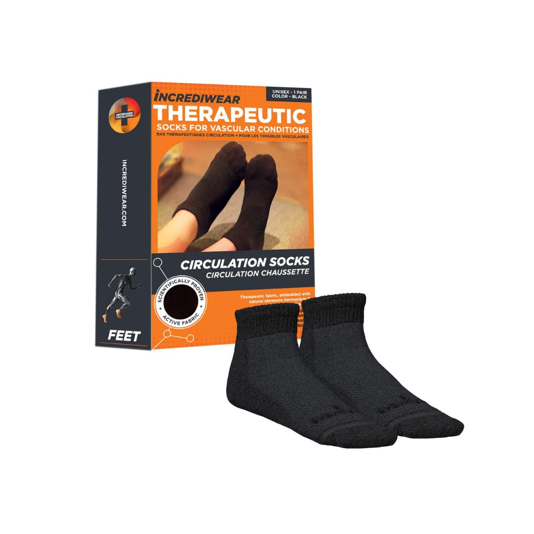 A pair of black Incrediwear Therapeutic Circulation Socks displayed in front of their orange and black retail packaging box on a plain white background.