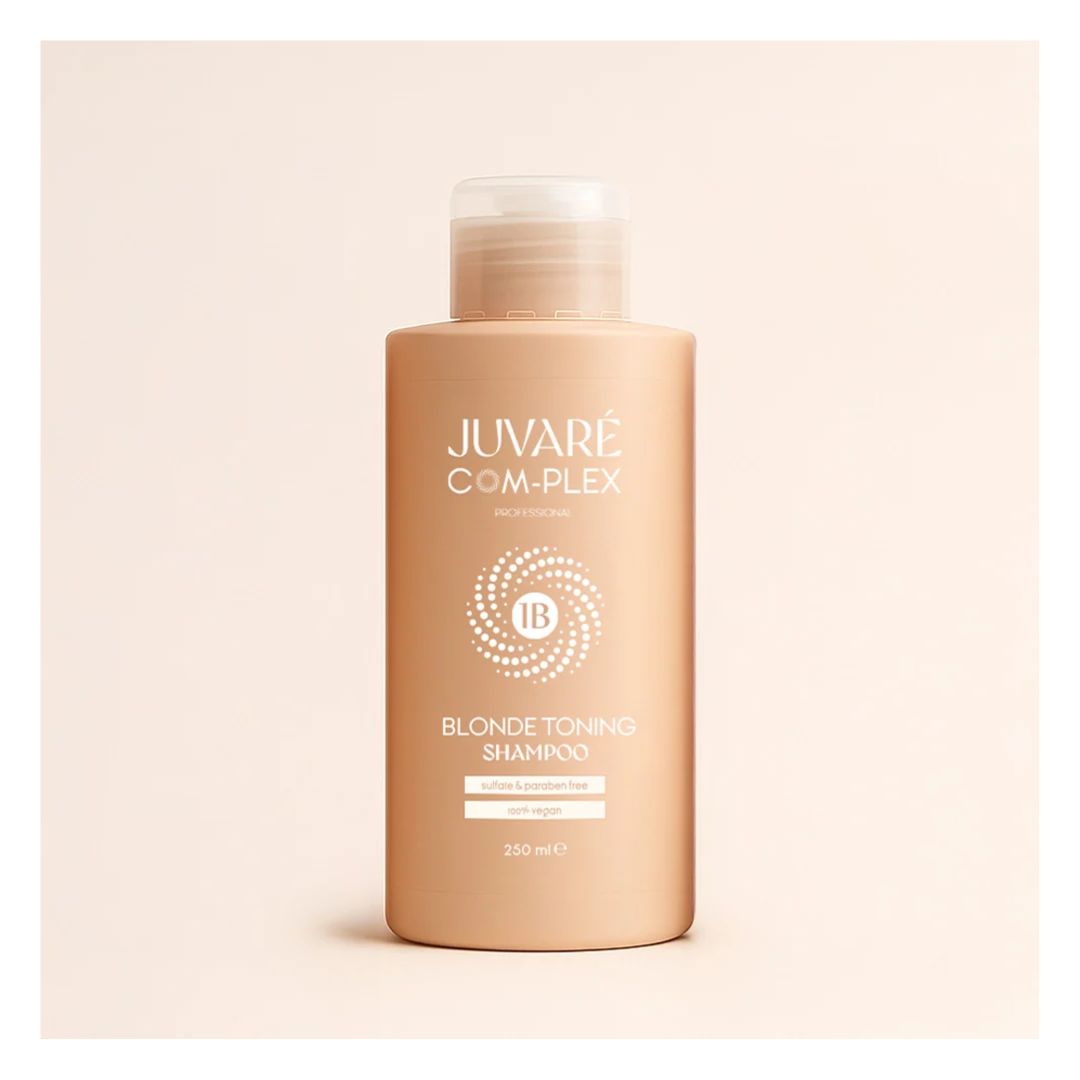 A bottle of Juvaré Com-Plex Blonde Toning Shampoo in a warm beige shade, set against a matching light beige background.