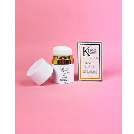 King of Beauty Gold Dust Daily Shampoo jar with its cap off next to its retail box, set against a solid pink background.