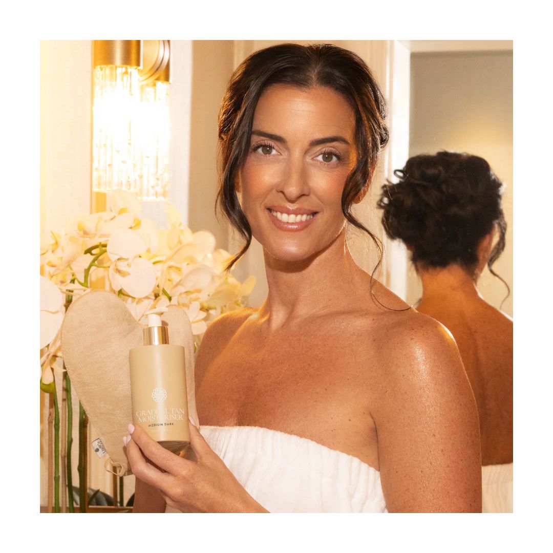 Lisa & Co. Gradual Tan Moisturiser Light/Medium container being hekd by a model in a warmly lit room