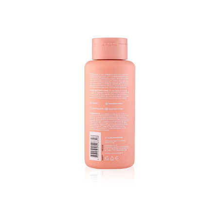 The back of a peach-colored plastic bottle with white text and a barcode, set against a plain white background with a soft reflection.