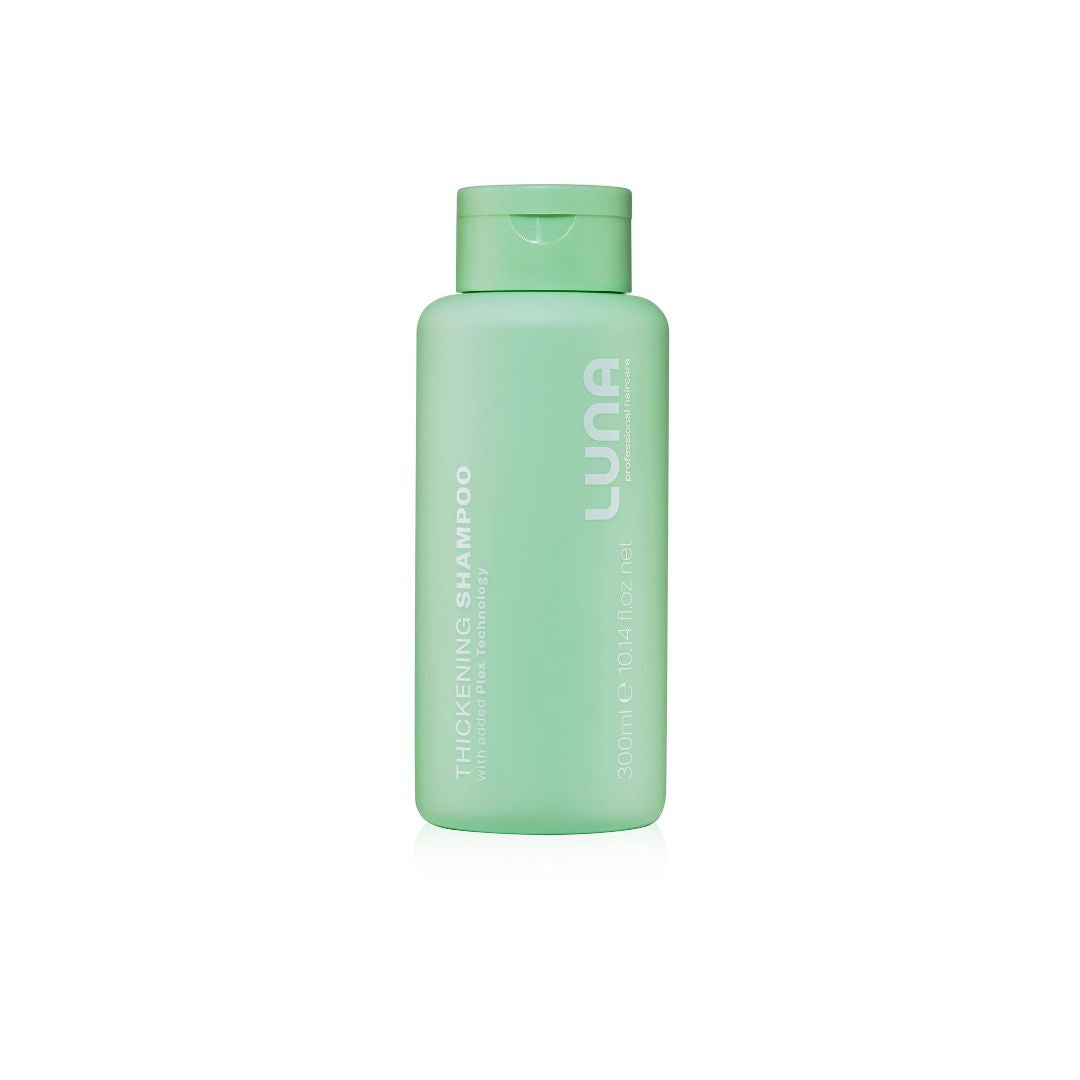 A mint green bottle of LUNA Thickening Shampoo on a solid white background.